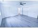 Bright bedroom with gray flooring, double closets, a ceiling fan, and a large window at 840 Brittle Bank Rd, Walterboro, SC 29488