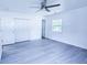 Bright bedroom with gray flooring, double closets, a ceiling fan, and a large window at 840 Brittle Bank Rd, Walterboro, SC 29488