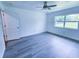 Bright bedroom with new gray flooring, a ceiling fan, and a large window providing natural light at 840 Brittle Bank Rd, Walterboro, SC 29488