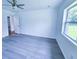 Well-lit bedroom with ceiling fan, gray flooring, and a large window providing natural light and backyard views at 840 Brittle Bank Rd, Walterboro, SC 29488