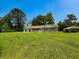 Quaint brick home featuring a large front yard, detached garage, and a sunny blue sky at 840 Brittle Bank Rd, Walterboro, SC 29488