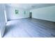 Bright living room featuring grey wood floors, white walls, and two windows providing natural light at 840 Brittle Bank Rd, Walterboro, SC 29488