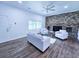 Cozy living room with brick fireplace, hardwood floors, and a bright window showcasing the outdoor view at 840 Brittle Bank Rd, Walterboro, SC 29488