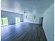 Spacious living room featuring new gray flooring, bright windows, and sliding glass doors to the exterior at 840 Brittle Bank Rd, Walterboro, SC 29488