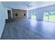 Spacious living room with grey wood floors, brick accent wall, and sliding glass doors to the outside at 840 Brittle Bank Rd, Walterboro, SC 29488