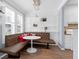 Bright dining area with booth seating next to a modern, all-white kitchen at 1014 Rosewood Ln, Mount Pleasant, SC 29464
