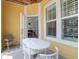 View of the sunny porch with white wicker chairs and table, with a glimpse into the dining area at 1014 Rosewood Ln, Mount Pleasant, SC 29464