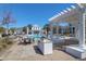 Community swimming pool with pergolas, lounge chairs, tables, and outdoor grill area on a sunny day at 1014 Rosewood Ln, Mount Pleasant, SC 29464
