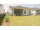 Backyard view featuring a screened in porch, grassy lawn and black metal fence at 1030 Grace Field Ave, Summerville, SC 29485