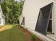 Side exterior featuring modern window shutters, manicured landscaping, and lush green lawn at 1030 Grace Field Ave, Summerville, SC 29485