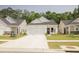 Charming one-story home featuring a pristine white exterior, a two-car garage, and a welcoming manicured front yard at 1030 Grace Field Ave, Summerville, SC 29485