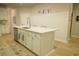 Stylish kitchen island featuring white cabinets, a stainless steel sink, seating, and quartz countertops at 1030 Grace Field Ave, Summerville, SC 29485