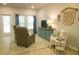 Bright living room with light-filled windows, hardwood floors, area rug and a blue accent cabinet at 1030 Grace Field Ave, Summerville, SC 29485