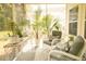Bright sunroom with wicker furniture, plants, and views of the outdoors at 1030 Grace Field Ave, Summerville, SC 29485