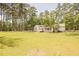 Rear exterior of single-story home with sliding glass doors that open to an expansive backyard at 1044 Academy Rd, Walterboro, SC 29488