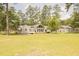 Rear exterior view of single-story home with large backyard, detached garage and picnic table at 1044 Academy Rd, Walterboro, SC 29488