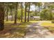 Property featuring a well-maintained lawn, a circular driveway, a house, and a matching detached garage at 1044 Academy Rd, Walterboro, SC 29488