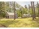 Exterior showcases home and garage with a lush green lawn and mature trees on a sunny day at 1044 Academy Rd, Walterboro, SC 29488
