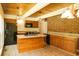 Kitchen with an island, granite countertops, wood cabinetry, brick wall, and modern appliances at 1044 Academy Rd, Walterboro, SC 29488