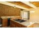 Close-up of the kitchen island showcasing the countertop, sink, and wood cabinets against a brick wall at 1044 Academy Rd, Walterboro, SC 29488