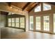 Sun-drenched room featuring wood-look floors, vaulted ceilings, and a wall of windows and doors leading to the backyard at 1044 Academy Rd, Walterboro, SC 29488