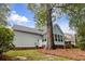 Exterior back of home with brick patio and stairs, lush green yard and mature trees at 111 Long Bow Rd, Summerville, SC 29485