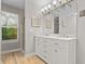 Modern bathroom with double sink vanity, wooden floors, and a window for natural light at 111 Long Bow Rd, Summerville, SC 29485