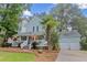 Charming two-story home boasts a welcoming front porch, mature trees, and a well-manicured lawn at 111 Long Bow Rd, Summerville, SC 29485
