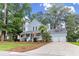 Charming two-story home boasts a welcoming front porch, mature trees, and a well-manicured lawn at 111 Long Bow Rd, Summerville, SC 29485