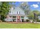 Two-story home features a charming front porch, mature trees, and well manicured front yard at 111 Long Bow Rd, Summerville, SC 29485