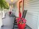 Charming front porch featuring rocking chairs, red door, ferns and flower filled planter at 111 Long Bow Rd, Summerville, SC 29485