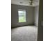 Neutral bedroom featuring plush carpet flooring, a ceiling fan, and a bright window offering a street view at 113 Lebsl Ct, Summerville, SC 29483
