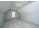 Large carpeted bonus room with sloped ceiling and decorative chandelier at 113 Lebsl Ct, Summerville, SC 29483