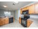 This updated kitchen showcases stainless steel appliances, wood cabinets, and tile flooring for a modern, functional space at 113 Lebsl Ct, Summerville, SC 29483