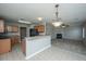 Open concept kitchen with light wood cabinets and black appliances looks into the adjacent living area with a fireplace at 113 Lebsl Ct, Summerville, SC 29483