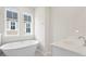 Bright bathroom features a standalone soaking tub, a large window, and modern fixtures at 113 Osprey Ridge Ln, Summerville, SC 29483