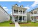 Inviting two-story home with a cozy porch, accented by an American flag and fresh landscaping at 113 Osprey Ridge Ln, Summerville, SC 29483
