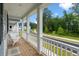 Inviting front porch with white columns, wooden floors, and relaxing chairs at 113 Osprey Ridge Ln, Summerville, SC 29483