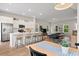Bright open-concept living room showcases stainless steel appliances, white cabinets, and an eat-in kitchen island at 113 Osprey Ridge Ln, Summerville, SC 29483