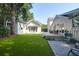 Landscaped backyard with patio and lawn, showcasing multiple pristine white buildings and verdant surrounding foliage at 1151 Camellia Dr, Mount Pleasant, SC 29464