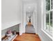 Hallway with hardwood floors, white trim, and a built-in shelf for storage at 1151 Camellia Dr, Mount Pleasant, SC 29464