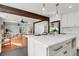 Elegant kitchen island featuring white cabinets, stone countertop, and adjacent living and dining areas at 1151 Camellia Dr, Mount Pleasant, SC 29464