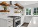 Modern kitchen with stainless steel appliances, floating wood shelves, and white subway tile backsplash at 1151 Camellia Dr, Mount Pleasant, SC 29464