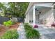 Inviting side porch with white columns, chairs, and manicured landscaping, creating a cozy outdoor space at 1151 Camellia Dr, Mount Pleasant, SC 29464