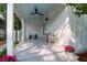 Side porch featuring white columns, a ceiling fan, and comfortable seating, perfect for relaxing and enjoying the outdoors at 1151 Camellia Dr, Mount Pleasant, SC 29464