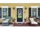 Charming front porch featuring a welcoming black door and wicker chairs decorated with patriotic accents at 127 White Pine Way, Summerville, SC 29485