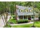 Charming home featuring a welcoming front porch, lush lawn, and brick chimney at 127 White Pine Way, Summerville, SC 29485