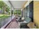 Inviting front porch with comfortable seating, classic columns, black shutters, and a view of the neighborhood at 127 White Pine Way, Summerville, SC 29485