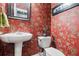 Stylish powder room featuring red wallpaper with floral pattern and a pedestal sink at 127 White Pine Way, Summerville, SC 29485
