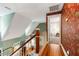 Elegant staircase landing with hardwood floors, floral wallpaper, and an open doorway to a carpeted room at 127 White Pine Way, Summerville, SC 29485